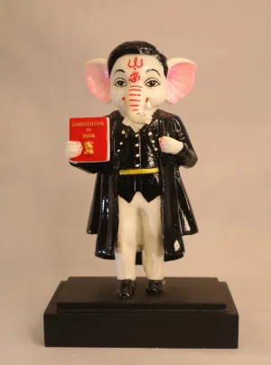Ganpati statue holding a red “Constitution of India” book