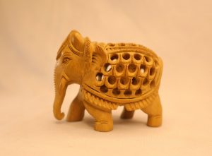 Hand-carved light-wood elephant with intricate jali (lattice) carving, decorative home decor artifact.