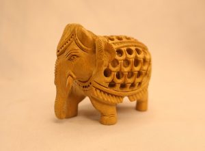 Hand-carved light-wood elephant with intricate jali (lattice) carving, decorative home decor artifact.