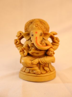 Small ivory-tone seated Ganpati (Ganesha) statue with traditional iconography on round base