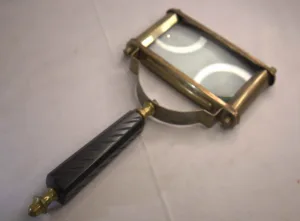 Rectangular brass-frame magnifying glass with carved dark handle